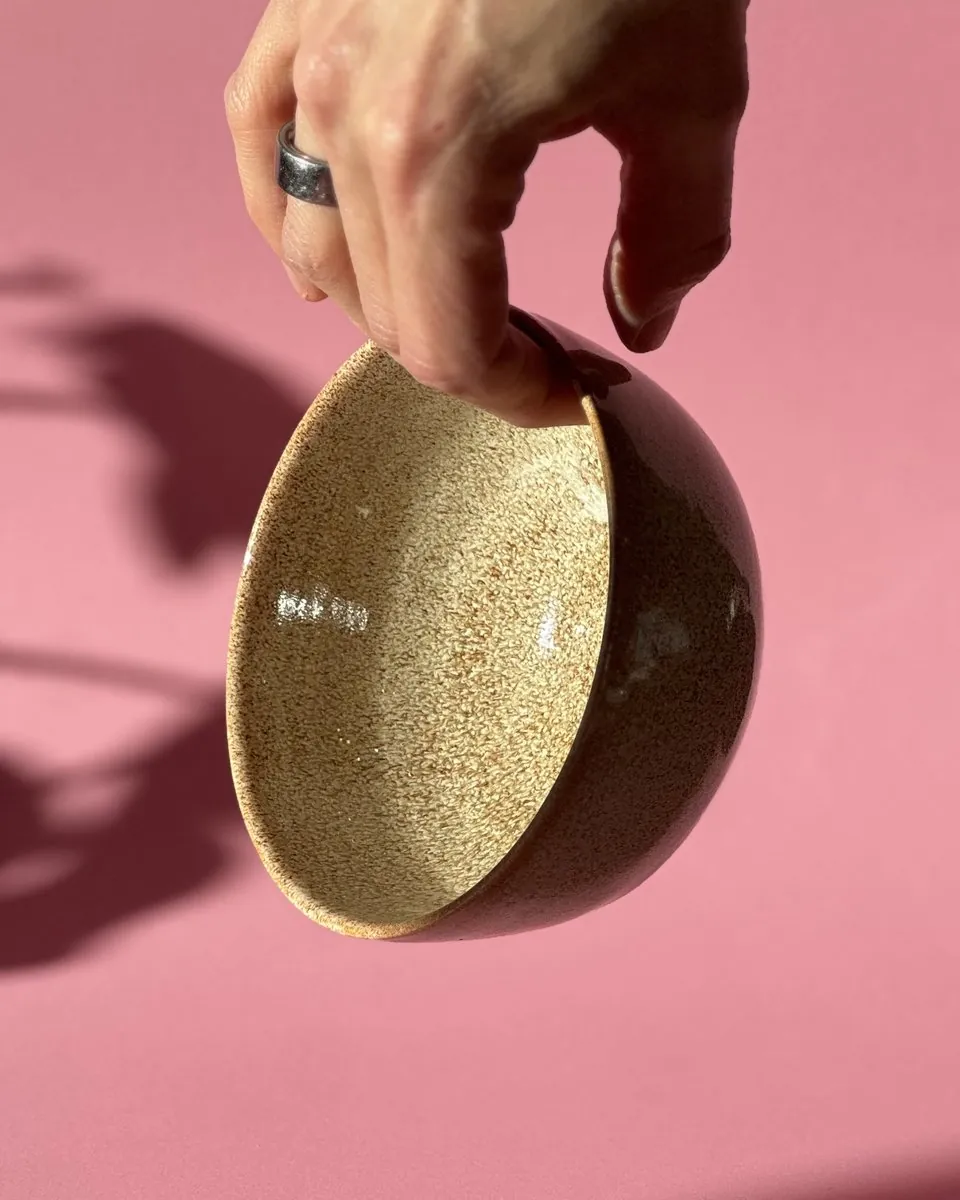 A speckled bowl held up in one hand
