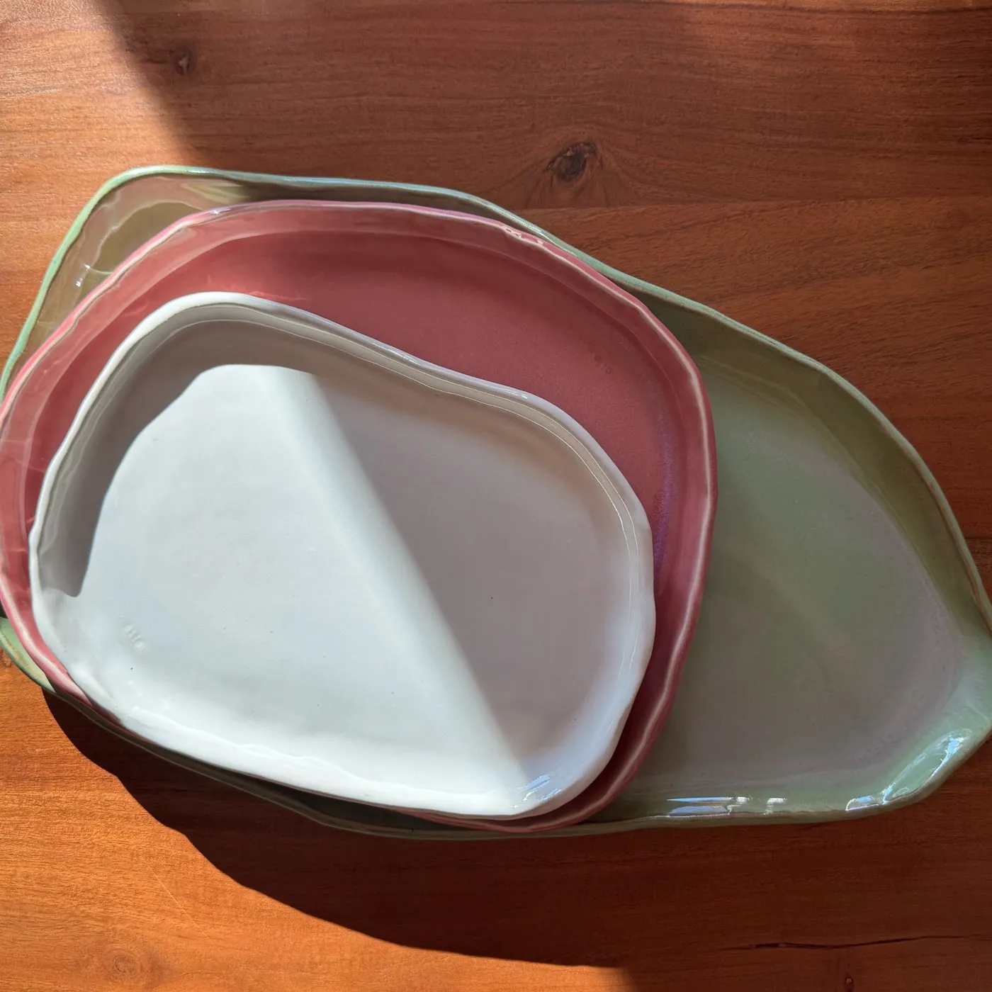 White, rose and sage platters nested one inside the other